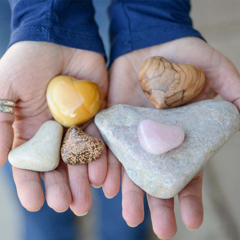 Heart-shaped stones in hands